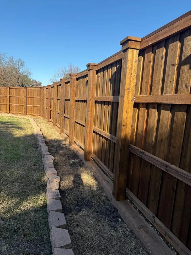 A pre-stained board-on-board fence with post caps.
